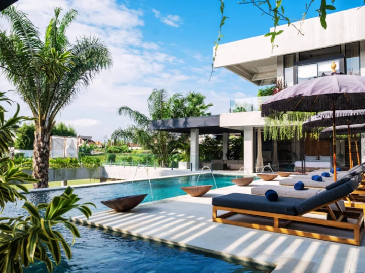 Poolside daybeds and parasols beside the villa
