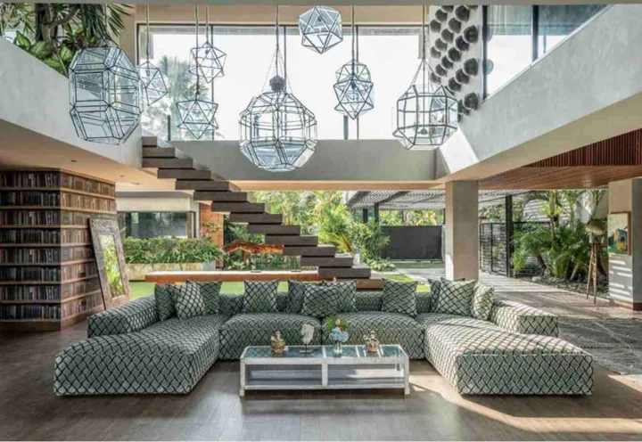 Green sunken lounge, floating staircase and sculptural pendant lights